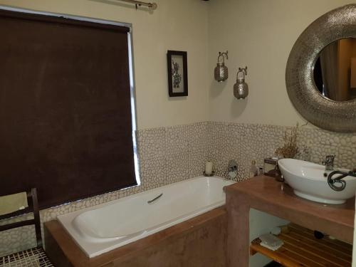 ein Badezimmer mit einer Badewanne und einem Waschbecken in der Unterkunft Lodge Twentyfour Mabalingwe Nature Reserve in Bela-Bela