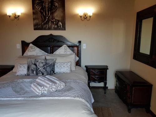 a bedroom with a large white bed with pillows at Lodge Twentyfour Mabalingwe Nature Reserve in Warmbaths