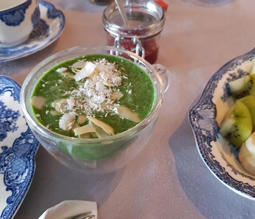 Atelier B&B 'Sinnestriel' في هيندلوبين: وعاء من الحساء على طاولة مع طبق من الطعام