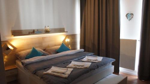 ein Schlafzimmer mit einem Bett mit blauen Kissen darauf in der Unterkunft Primo Relax in Starý Smokovec