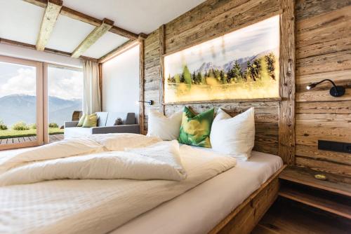 a bedroom with a large bed with a wooden wall at Ahner Berghof in Rodengo