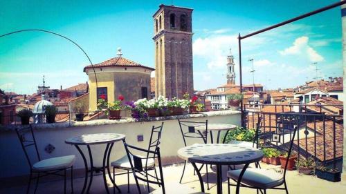 a patio with tables and chairs on a balcony at B&B La Terrazza Dei Miracoli in Venice