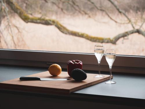 a wooden cutting board with two glasses of wine at Swiss Lake Lodge in Noville