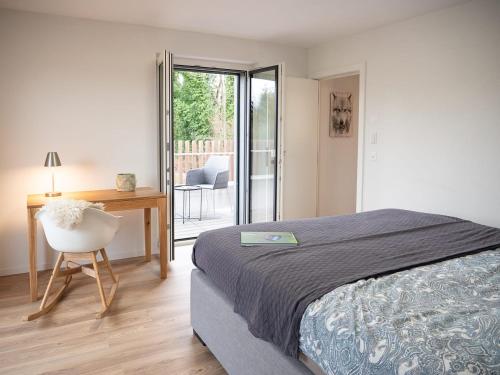 a bedroom with a bed and a desk and a chair at Swiss Lake Lodge in Noville