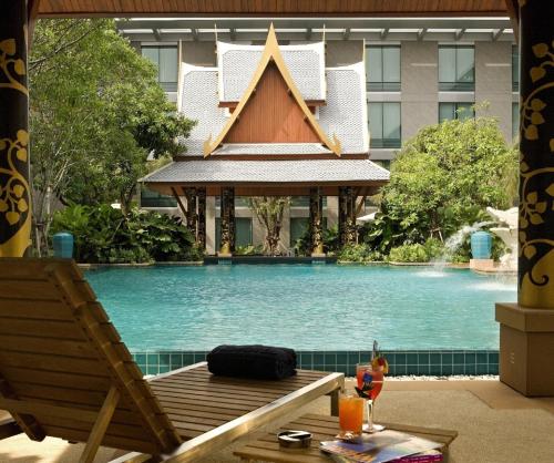 a swimming pool with a gazebo in front of a building at Hyatt Regency Bangkok Suvarnabhumi Airport in Lat Krabang