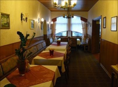 ein Restaurant mit Tischen und Stühlen in einem Zimmer in der Unterkunft Hotel zur Post Garni in Landkern