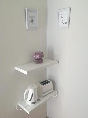 a white kitchen with white shelves and a toaster at Madeira House in Calheta