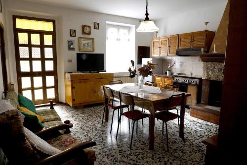sala de estar con mesa y sillas y cocina en A casa di Stella en Vaccarile