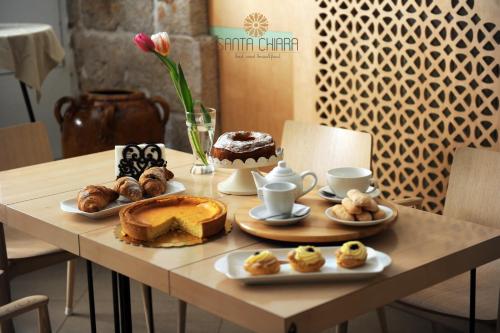 B&B Dimora Santa Chiara في ألتامورا: طاولة عليها الحلويات والكعك المتنوع