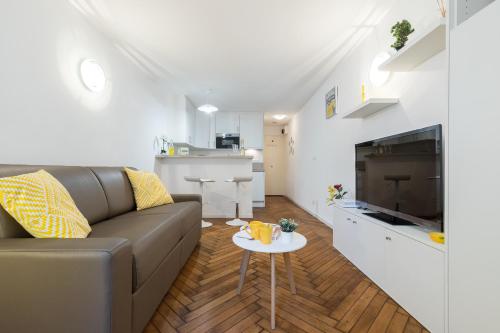 ein Wohnzimmer mit Sofa und Tisch in der Unterkunft COSY MALTE in Menton