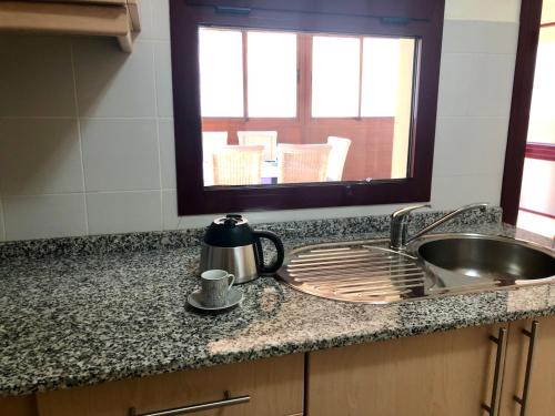 a kitchen counter with a sink and a mirror at Apartamento Las Tejas Mogán in Mogán