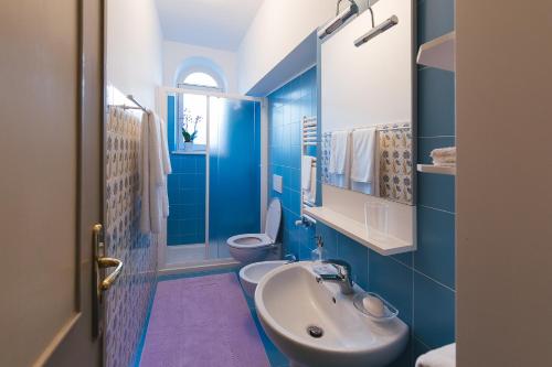 a blue bathroom with a sink and a toilet at Casa De Angelis Orange & Blue in Sant'Agnello