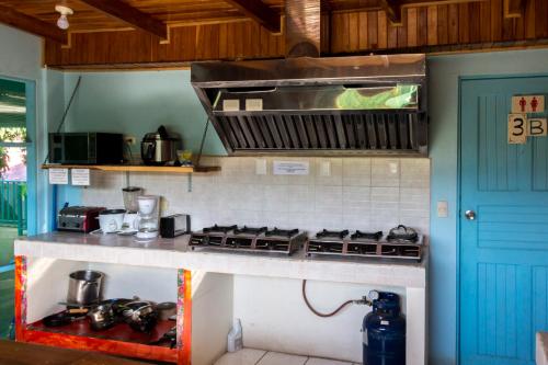 a kitchen with a stove top oven and a sink at Hostel Samara in Sámara