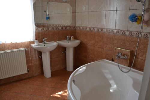 y baño con bañera y lavamanos. en Arany Tisza Vendégház, en Poroszló