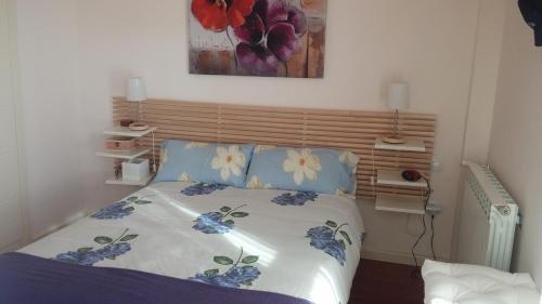 Un dormitorio con una cama con flores azules. en Apartamento en Las Margas, en Sabiñánigo