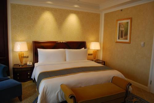 a hotel room with two beds and a lamp at Grand Central Hotel Shanghai in Shanghai