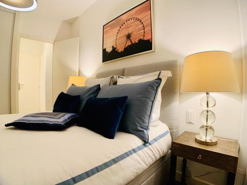 a bedroom with a bed with blue pillows and a lamp at Apartment Massena in Nice