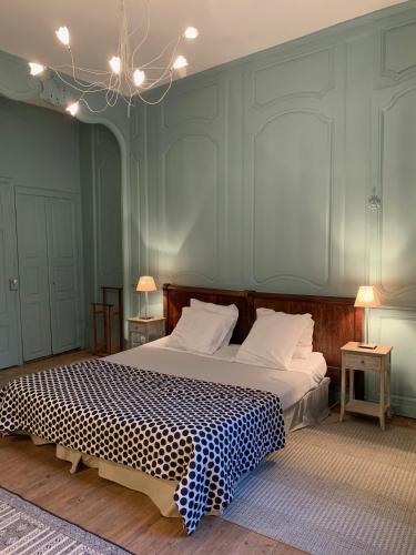 une chambre avec un grand lit avec une couverture à carreaux dans l'établissement L'Annexe Apparthôtel du 11 D, 3 étoiles, à Besançon