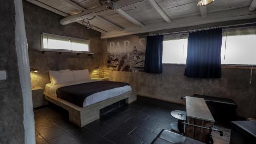1 dormitorio con 1 cama, escritorio y ventanas en La Bicok EcoLodge, en Mindo