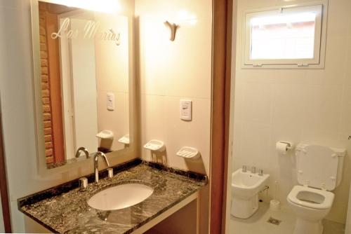 y baño con lavabo, aseo y espejo. en Cabañas Las Marias en San Rafael