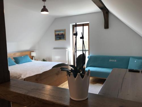 Tourist farm Artisek في Štore: غرفة نوم مع سرير وطاولة مع نبات الفخار