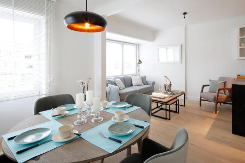 a dining room with a table and chairs and a living room at ZEN op Vakantie - Zen aan Zee Duinbergen in Knokke-Heist
