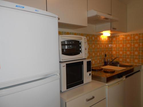 a kitchen with a white refrigerator and a microwave at T2 Bassin d'Arcachon, 100m plage, centre-ville in Andernos-les-Bains