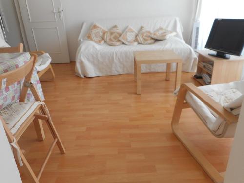 a living room with a couch and wooden floors at T2 Bassin d'Arcachon, 100m plage, centre-ville in Andernos-les-Bains