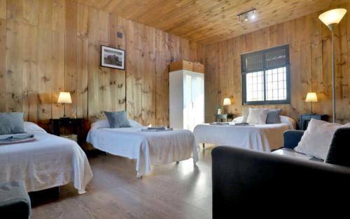 Habitación con 2 camas en una habitación con paredes de madera. en Casa Rural Ecuestre, en Fuente Palmera