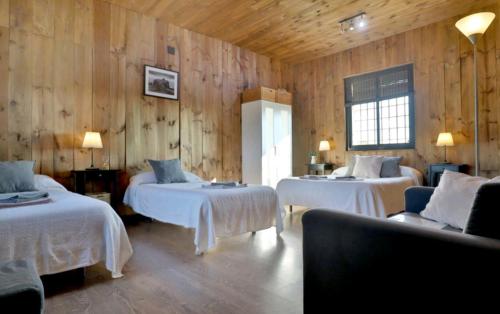 a room with two beds in a room with wooden walls at Casa Ecuestre Carmen Martínez in Fuente Palmera