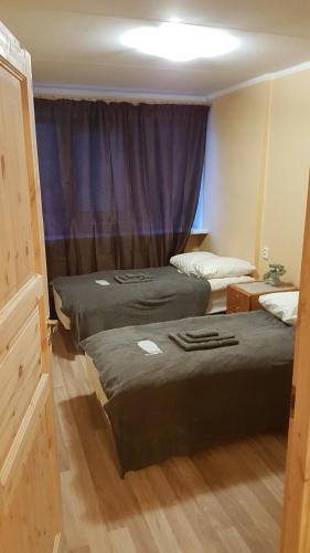 two beds in a room with a purple curtain at Adart Apartment in Narva