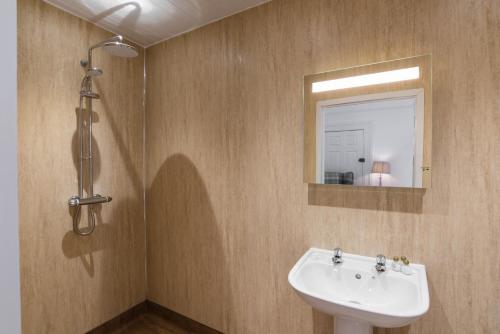 a bathroom with a sink and a mirror at No 47 Marine Terrace in Aberystwyth