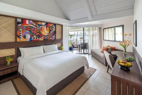 a bedroom with a bed and a living room at Shangri-La Yanuca Island, Fiji in Voua