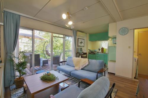 a living room with a blue couch and a table at Villent Atagawa Terrace in Higashiizu