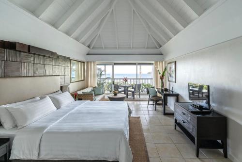 a bedroom with a large bed and a balcony at Shangri-La Yanuca Island, Fiji in Voua