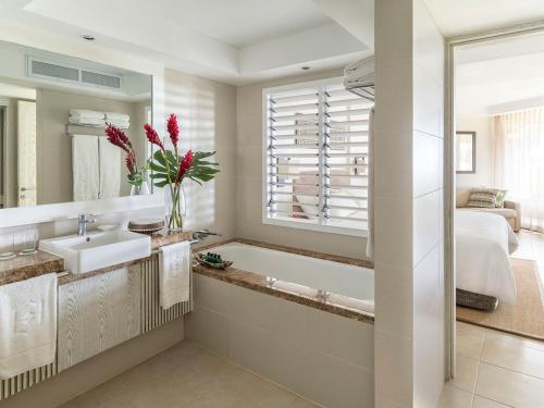 a bathroom with a sink and a tub and a bed at Shangri-La Yanuca Island, Fiji in Voua