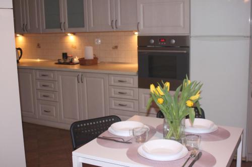a kitchen with a table with plates and flowers on it at Dąbrowski in Nadarzyn