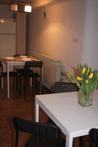 a room with tables and chairs and a vase of flowers on a table at Dąbrowski in Nadarzyn