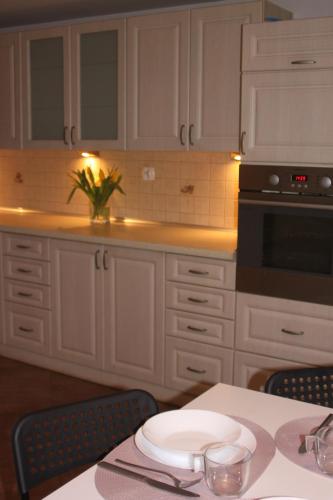 a kitchen with white cabinets and a table with a plate at Dąbrowski in Nadarzyn
