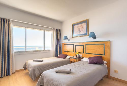 een hotelkamer met 2 bedden en een raam bij KEY-WISE La Mar Salá Primera Linea de Playa con Parking incluido y Piscinas in Fuengirola