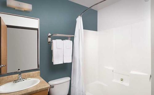 WoodSpring Suites Holland - Grand Rapids في هولاند: حمام مع مرحاض ومغسلة ومرآة