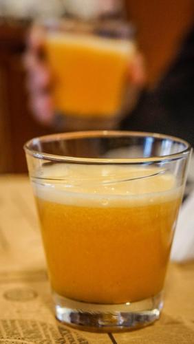 a glass of orange juice sitting on a table at Hotel Francés La Maison in Pasto
