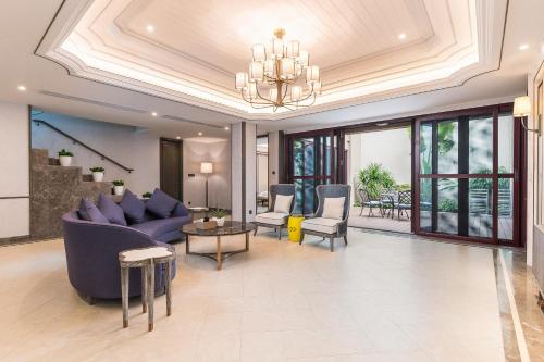 a living room with a couch and chairs and a chandelier at HaitangBay Loosen Coast Resort Villas in Sanya