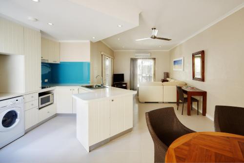 
a kitchen with a stove a refrigerator and a microwave at Seashells Broome in Broome
