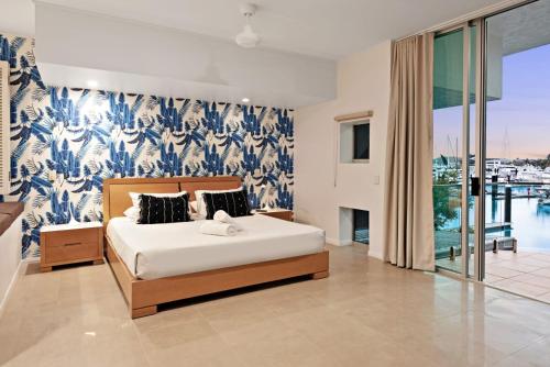 1 dormitorio con 1 cama con papel pintado azul y blanco en Pavillion 3 Absolute Waterfront 4 Bedroom 2 Lounge Room Plunge Pool + Golf Buggy, en Hamilton Island