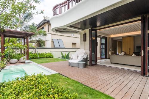 an outdoor patio with a pool and a house at HaitangBay Loosen Coast Resort Villas in Sanya