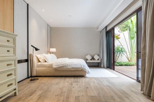 a bedroom with a bed and a large window at HaitangBay Loosen Coast Resort Villas in Sanya