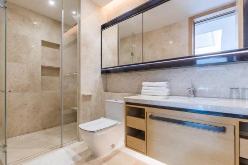 a bathroom with a toilet and a glass shower at HaitangBay Loosen Coast Resort Villas in Sanya