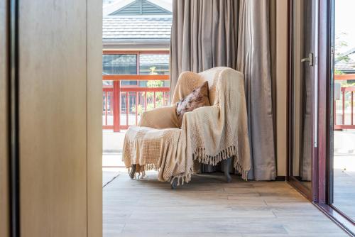 a chair with a blanket sitting next to a window at HaitangBay Loosen Coast Resort Villas in Sanya