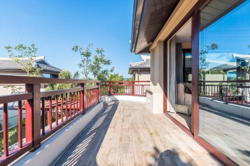 a balcony with a view of a house at HaitangBay Loosen Coast Resort Villas in Sanya